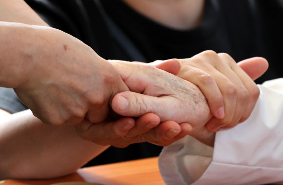 추석을 하루 앞둔 20일 오전 강원 춘천시의 한 요양원에서 입소 어르신이 딸들과 면회하며 손을 잡고 있다. 2021.9.20  연합뉴스