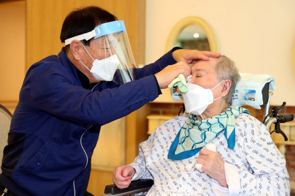 지난 17일 오전 경기 광주시 선한빛요양병원에서 남편 최병록 씨가 두 달 만에 만난 아내 박정이 씨의 눈물을 닦아주고 있다. 두 달간 만나지 못했던 이들은 지난 13일부터 오는 26일까지 실시되는 정부의 추석특별방역대책에 따라 접촉 면회 기회를 갖게 됐다. 2021.9.20  보건복지부 제공