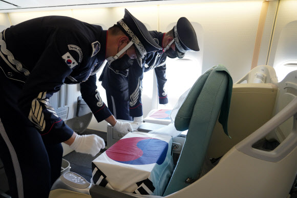 문재인 대통령과 김정숙 여사가 참석한 가운데 22일(현지시각) 미국 히캄 공군기지 19번 격납고에서 열린 한미 유해 상호 인수식에서 의장병이 유해를 공군1호기 좌석에 안치하고 있다. 2021.9.23  연합뉴스