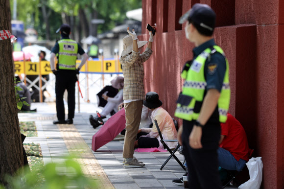 신종 코로나바이러스 감염증(코로나19) 확산 방지를 위해 도심내 집회금지가 이어지고 있는 가운데 26일 오전 서울 종로구 광화문광장 인근에서 사랑제일교회 신도들이 예배하고 있다.  사랑제일교회는 사회적 거리두기 4단계로 대면 예배가 금지된 이후에도 매주 일요일 대면 예배를 강행해 2차례의 운영 중단 명령을 받았으나 이를 무시하고 대면 예배를 계속한 끝에 지난달 19일 성북구로부터 시설폐쇄 명령을 받았다. 2021.9.26  연합뉴스