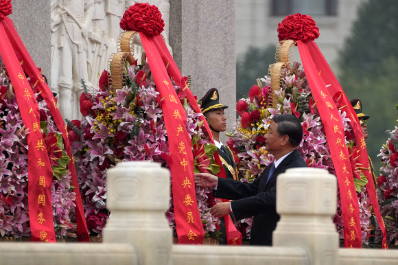 시진핑 국가 주석이 30일(현지시간) 중국의 열사기념일에 베이징 톈안먼 광장의 인민영웅기념비에 경의를 표한 후 화환을 매만지고 있다. AP 연합뉴스