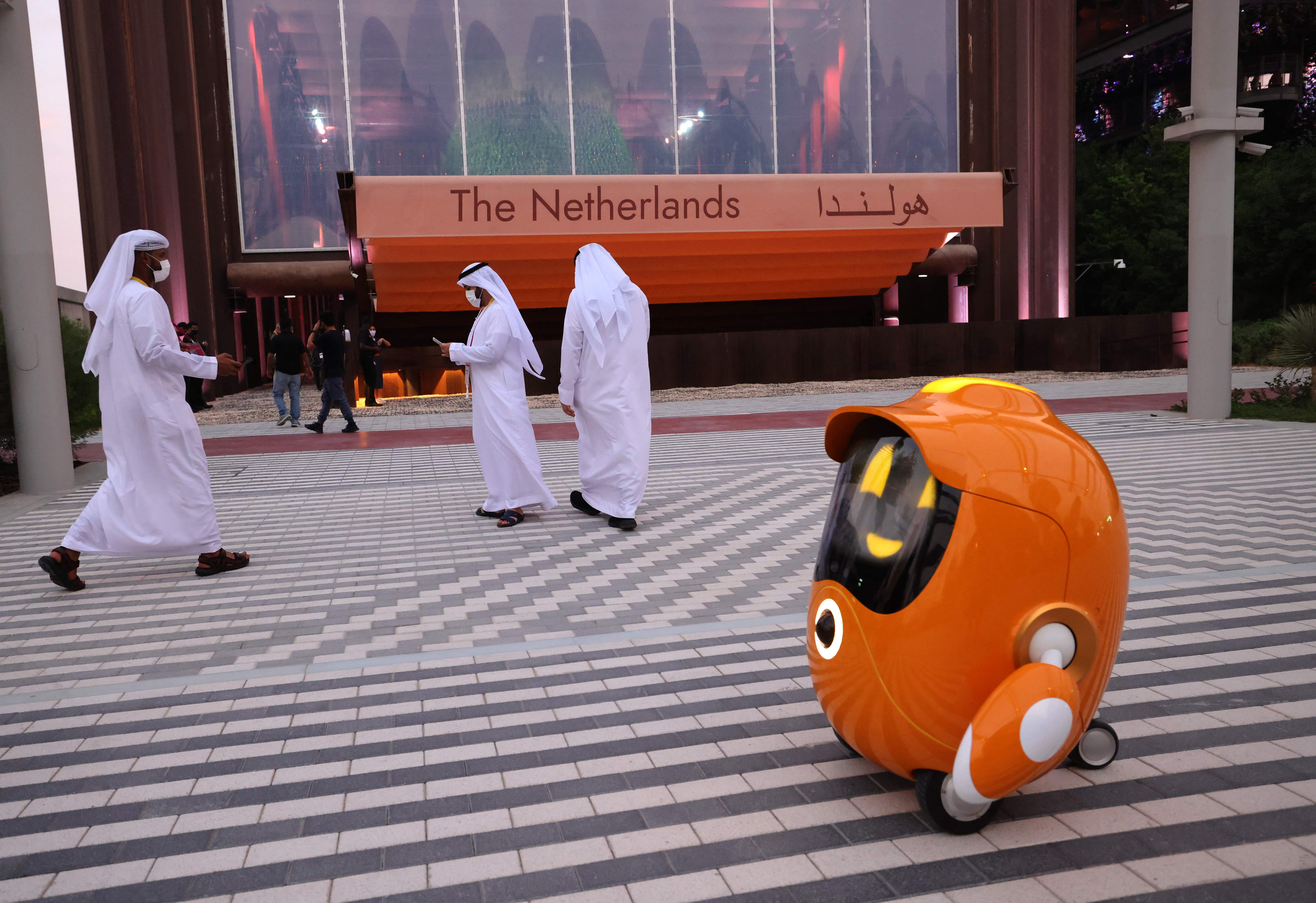코로나19 여파로 예정보다 1년 늦게 아랍에미리트(UAE) 두바이에서 개최된 2020 세계엑스포에 방문한 관람객들이 오렌지색 로봇이 안내하는 네덜란드관 앞을 지나고 있다. 두바이 AFP 연합뉴스