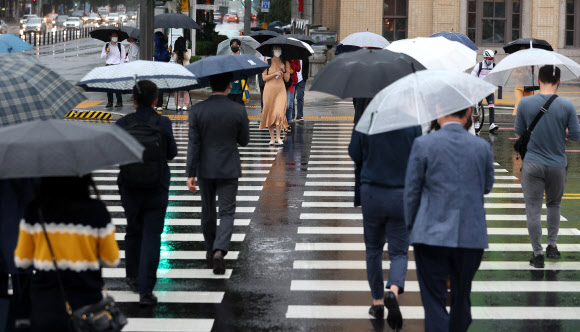 중부지방에 비가 내리는 6일 오전 서울 광화문광장에서 시민들이 우산을 쓴 채 걸어가고 있다. 2021.10.6  연합뉴스
