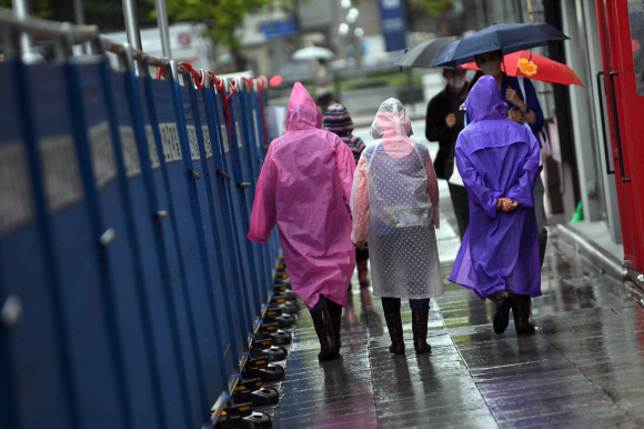 전국 곳곳에 비가 내린 6일 서울 중구 광화문 일대에서 시민이 우비를 쓰고 발걸음을 옮기고 있다. 2021. 10. 6 박윤슬 기자 seul@seoul.co.kr