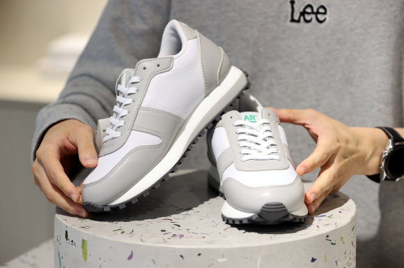 6일 서울 성동구 LAR 매장에서 직원이 폐페트병 소재로 만든 운동화를 선보이고 있다. 이 운동화는 롯데케미칼 주관으로 7개 업체가 참여한 플라스틱 자원선순환 프로젝트인 ‘프로젝트 루프’(Project LOOP)를 통해 제작된 제품으로, 신동빈 롯데그룹 회장이 평소 자주 신는 것으로 알려졌다. 2021.10.6  연합뉴스