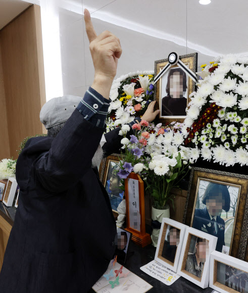 성추행 피해 신고 후 극단적 선택을 한 공군 고(故) 이 모 중사의 부친 A씨가 7일 오후 성남  국군수도병원 장례식장에 마련된 고(故) 이 중사 추모소에서 영정사진을 어루만지고 있다. 국방부는 15명을 기소하는 등 38명에 대한 문책을 예고했지만, 이 중사 사망에 책임론이 거셌던 부실 초동수사 담당자와 지휘부는 단 한 명도 기소되지 않았다.  이 중사의 부친 A씨는 이날 국방부 발표 직후 전화 인터뷰에서 “초동수사를 맡았던 사람 중 기소된 사람이 단 한 명도 없다”며 “대통령 말만 믿고 신뢰하며 지켜봤는데, (결과를 듣고) 피눈물이 난다”고 언성을 높였다. 2021.10.7  연합뉴스