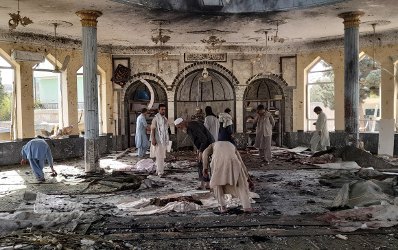 8일(현지시간) 자살폭탄 공격이 발생한 아프가니스탄 북부 쿤두즈의 수니파 시아파 사이드 아바드 모스크 내부를 사람들이 살펴보고 있다. 쿤두즈 AP 연합뉴스 