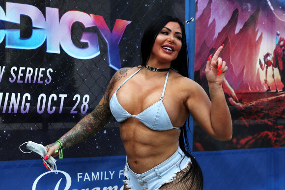 A woman dressed in costume points while holding a protective face mask, amid the coronavirus disease (COVID-19) pandemic, before attending the 2021 New York Comic Con at the Jacob Javits Convention Center in New York City, U.S., October 8, 2021. REUTERS/Shannon Stapleton/2021-10-09 05:32:57/ <연합뉴스