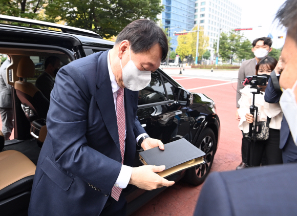 국민의힘 대권 주자인 윤석열 전 검찰총장이 10일 오전 서울 여의도 순복음교회 예배에 참석하기 위해 성경책을 들고 차에서 내리고 있다.2021. 10. 10 김명국 선임기자 daunso@seoul.co.kr