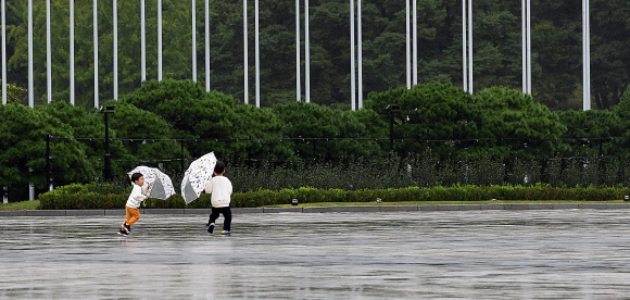 가을비가 내리는 10일 서울 송파구 올림픽공원 평화의광장에서 아이들이 우산으로 장난을 치며 휴일을 보내고 있다. 2021.10.10 오장환 기자 5zzang@seoul.co.kr