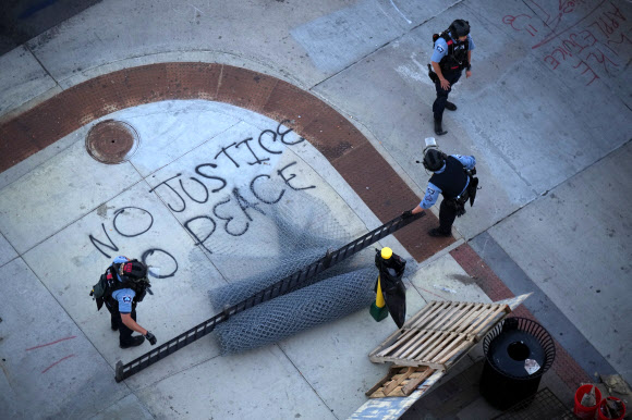 지난 6월 미네소타주 미니애폴리스에서 경찰들이 바리케이드를 치려고 준비하고 있다. AP