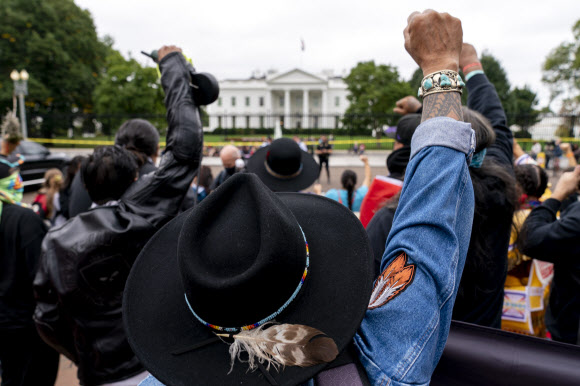 11일(현지시간) 미국 워싱턴DC 백악관에서 원주민들이 기후변화 대응을 촉구하는 시위를 벌이고 있다. AP