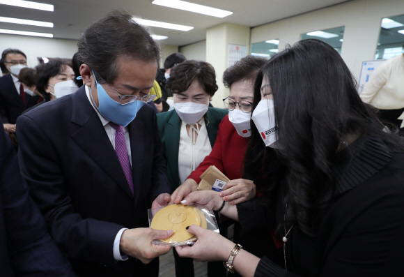 홍준표 국민의힘 대선 경선 후보가 14일 경기도 의정부 제일시장내 상가번영회에서 열린 의정부갑,을 당원인사 행사에 참석, 지지자에게 달고나를 선물 받고 있다.2021. 10. 14 정연호 기자 tpgod@seoul.co.kr