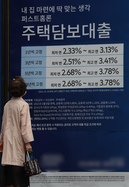 금융 당국이 14일 올 4분기 가계대출 증가율 관리에서 전세대출을 제외하기로 결정한 가운데 한 시민이 이날 서울시내의 시중은행에 내걸린 주택담보대출 광고를 보고 있다. 뉴스1