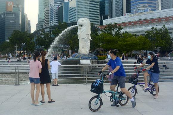아시아에서는 가장 먼저 코로나 방역조치 완화를 발표하며 코로나와의 공존에 나선 싱가포르 시민들이 지난달 26일 마스크를 쓴 채 공원에서 자전거를 타며 주말을 즐기고 있다. 싱가포르 AP 연합뉴스