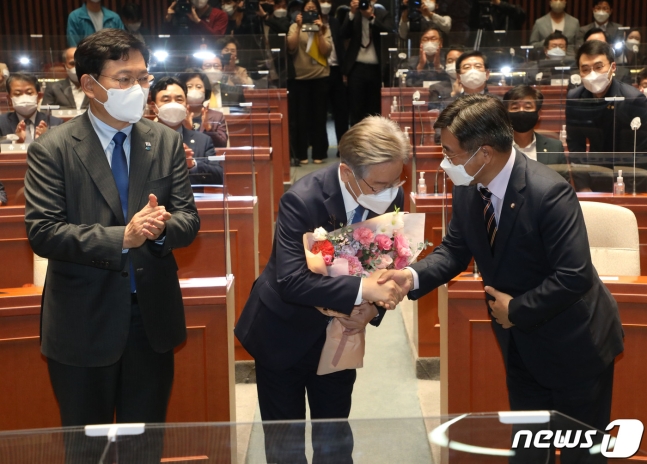 더불어민주당 대선 후보인 이재명 경기도지사가 15일 오전 서울 국회에서 열린 더불어민주당 의원총회에 참석, 윤호중 원내대표가 준 꽃다발을 받고 있다.