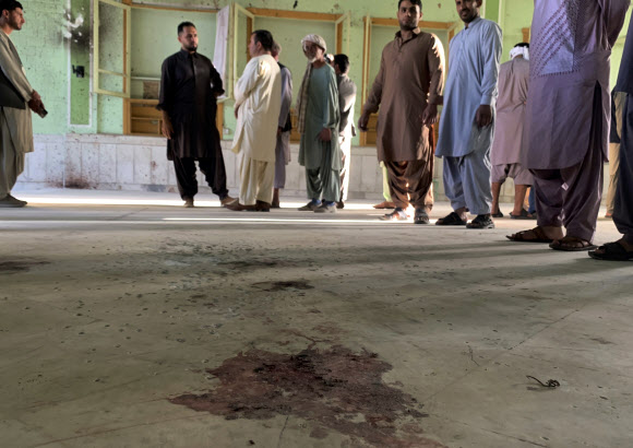 아프가니스탄 남서부 칸다하르에 있는 이맘 바르가 모스크에 자살폭탄 테러가 발생한 15일(현지시간) 시신 수습 등을 마친 신도들이 마룻바닥에 핏자국이 역력한 주위에 둘러서 얘기를 나누고 있다. 칸다하르 AP 연합뉴스 