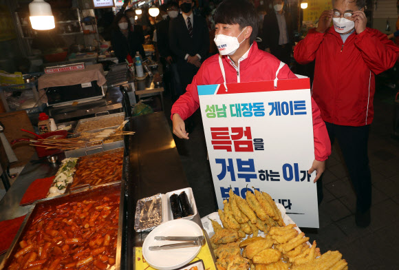 ‘이재명 대장동 게이트 특검 촉구 도보 1인 시위’에 나선 국민의힘 이준석 대표가 16일 오후 경남 창원시 마산합포구 부림동 부림시장 내 떡볶이 매장 거리를 지나고 있다. 해당 거리는 지난 6월 17일 경기 이천 쿠팡 물류센터 화재 사고 당시 이재명 경기지사와 맛 칼럼니스트 황교익 씨가 먹방을 하던 곳이다. 2021.10.16  연합뉴스