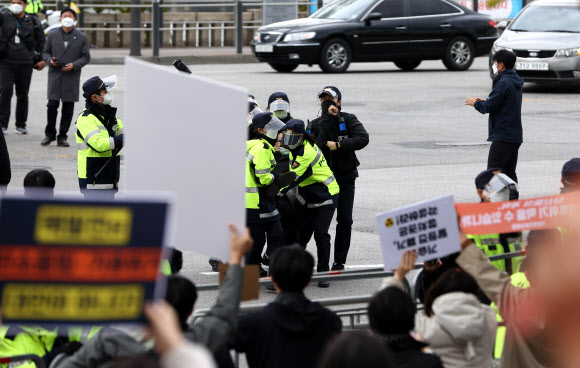 18일 탄소중립위원회 전체회의가 열리는 노들섬 다목적홀 앞 도로에서 감축 시나리오 전면 재수립 등을 요구하는 기후위기비상행동 등 환경단체 관계자들이 택시에서 내려 회의장 진입을 시도하다 경찰에 막히고 있다. 2021.10.18 <br>연합뉴스