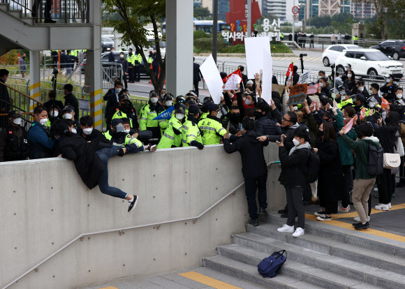 18일 탄소중립위원회 전체회의가 열린 노들섬 다목적홀 건너편에서 기후위기비상행동 등 환경단체 회원들이 회의를 마치고 나오는 정부 관계자들을 향해 감축 시나리오 전면 재수립 등을 요구하며 항의하고 있다. 2021.10.18  연합뉴스