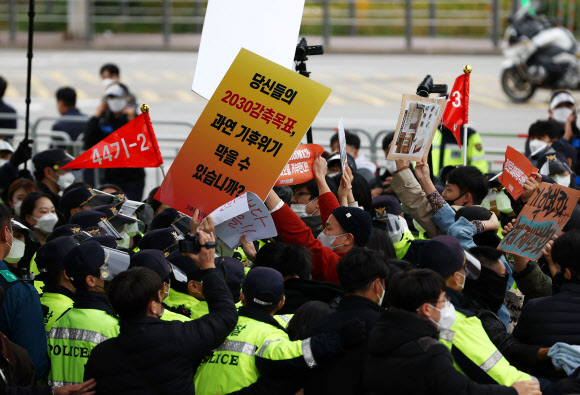18일 탄소중립위원회 전체회의가 열리는 노들섬 다목적홀 건너편에서 감축 시나리오 전면 재수립 등을 요구하는 기후위기비상행동 등 환경단체 관계자들이 경찰과 충돌하고 있다. 2021.10.18  연합뉴스