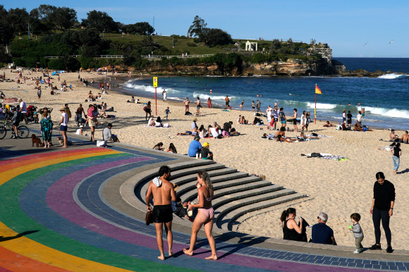 코로나19로 인한 봉쇄령이 해제되자 18일(현지시간) 호주 시드니 쿠지 비치에서 시민들이 물놀이와 일광욕을 즐기고 있다. 로이터 연합뉴스