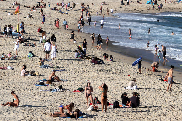 코로나19로 인한 봉쇄령이 해제되자 18일(현지시간) 호주 시드니 쿠지 비치에서 시민들이 물놀이와 일광욕을 즐기고 있다. 로이터 연합뉴스