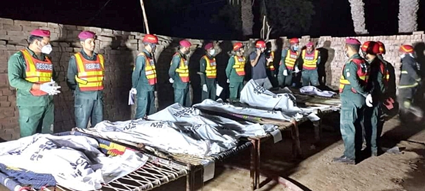 17일 파키스탄 구조대가 펀자브주 무자파가르시 알리 푸르 지역 방화살인사건 현장에서 수습한 시신 주변에 모여 있다./로이터 연합뉴스