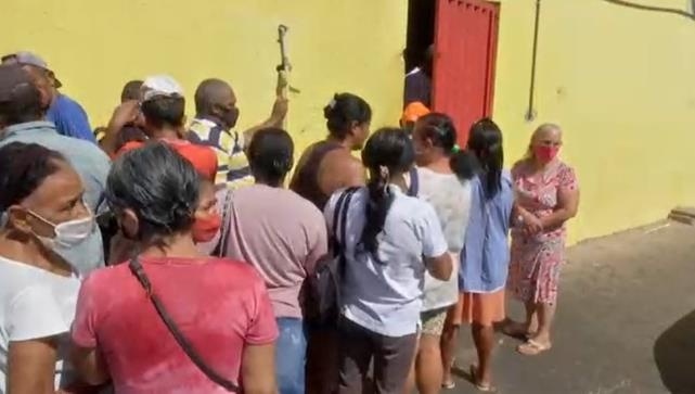 소뼈와 소고기 찌꺼기를 나눠주는 정육점 앞에 줄을 선 브라질 주민들 . 브라질 TV 센트루 아메리카 캡처