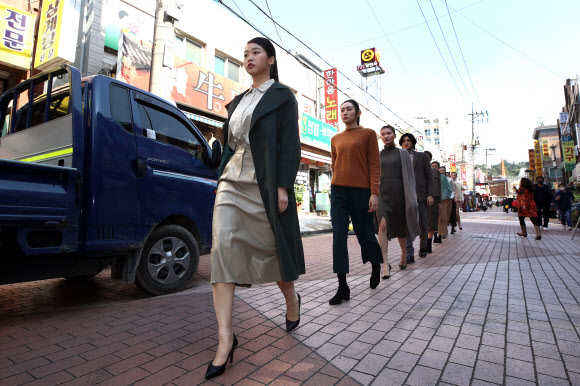 22일 오후 서울 금천구 아뜰리에440에 인근에서 열린 ‘2021 금천 골목길 패션쇼’에서 모델들이 골목길 런웨이를 걷고 있다. 이번 골목길 패션쇼는 코로나 팬데믹 시대 소상공인 의류 제조 업체들을 살리기 위해 마련됐다. 2021.10.22  연합뉴스