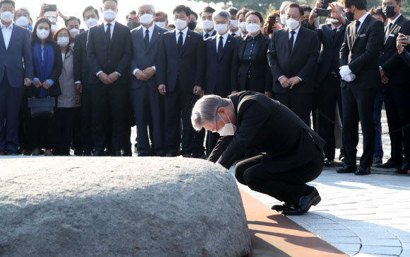 더불어민주당 대선 후보인 이재명 경기도지사가 22일 오후 경남 김해시 진영읍 봉하마을 노무현 전 대통령 묘역을 참배하며 앉아 너럭바위를 만지고 있다. 2021.10.22  연합뉴스