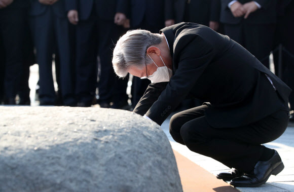더불어민주당 대선 후보인 이재명 경기도지사가 22일 오후 경남 김해시 진영읍 봉하마을 노무현 전 대통령 묘역을 참배하며 앉아 너럭바위를 만지고 있다. 2021.10.22  연합뉴스