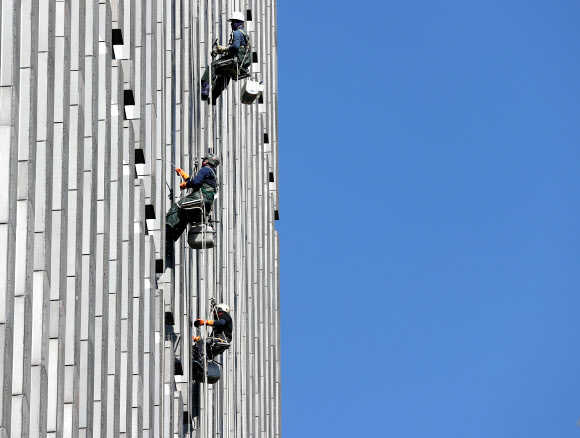 24일 오전 서울시내 한 빌딩에서 청소업체 직원들이 외벽 유리창을 닦고 있다. 2021.10.24  연합뉴스