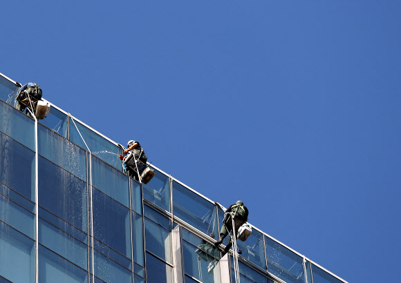 24일 오전 서울시내 한 빌딩에서 청소업체 직원들이 외벽 유리창을 닦고 있다. 2021.10.24  연합뉴스