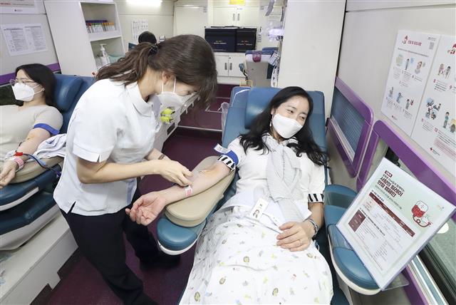 ‘광화문 원팀’ 소속 임직원이 대한적십자사 헌혈 버스에서 헌혈을 하고 있다. KT 제공