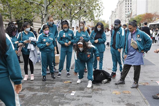 미국 뉴욕 맨해튼 일대에서 지난달 26일(현지시간) 열린 오징어 게임 체험 행사에서 미국인들이 딱지놀이를 하고 있다.  한국관광공사 뉴욕지사 제공