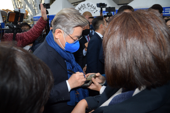 이재명 더불어민주당 대통령 후보가 2일 오후 서울 송파구 올림픽공원 체조경기장에서 제20대 대통령선거 선거대책위원회 출범식을 마친 후 지지자의 휴대전화에 사인을 남기고 있다.2021. 11. 2. 김명국 선임기자 daunso@seoul.co.kr