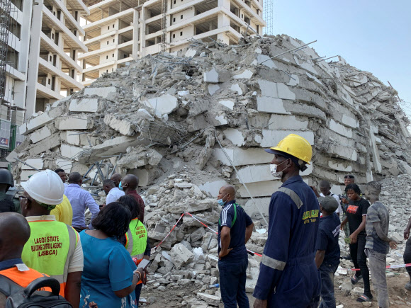 1일(현지시간) 나이지리아 라고스 이코이 지역에서 건물이 붕괴해 잔해만 남은 가운데 구조 요원들이 생존자 수색 작업을 벌이고 있다. 라고스 로이터 연합뉴스