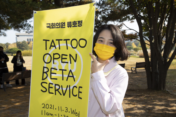 지난 6월 타투업을 합법화하는 내용의 법안을 발의한 류호정 정의당 의원(왼쪽)이 3일 국회 의원회관 앞에서 열린 타투 오픈베타서비스 행사에서 포즈를 취하고 있다.2021. 11. 3  김명국 선임기자 daunso@seoul.co.kr