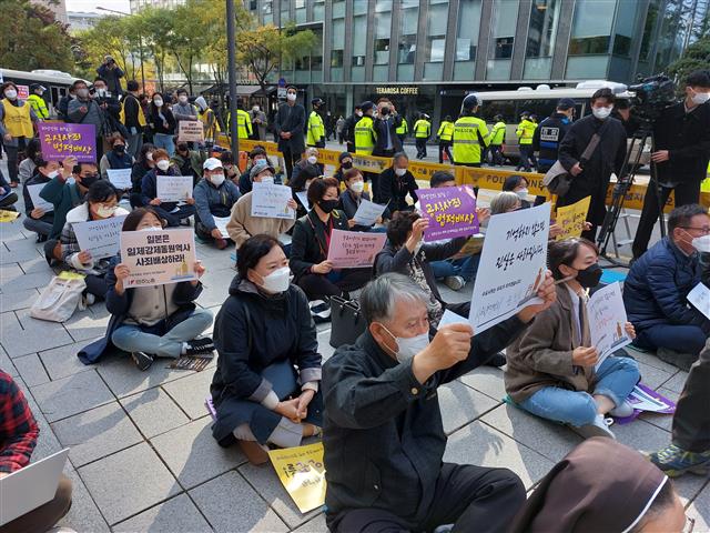 위드 코로나 시행을 계기로 ‘일본군 성노예제 문제해결을 위한 수요집회’가 약 1년 4개월 만에 집회 형태로 열렸다. 3일 서울 종로구 연합뉴스 사옥 앞에서 집회 참여자들이 일본의 사죄와 배상을 요구하는 피켓을 들고 있다.