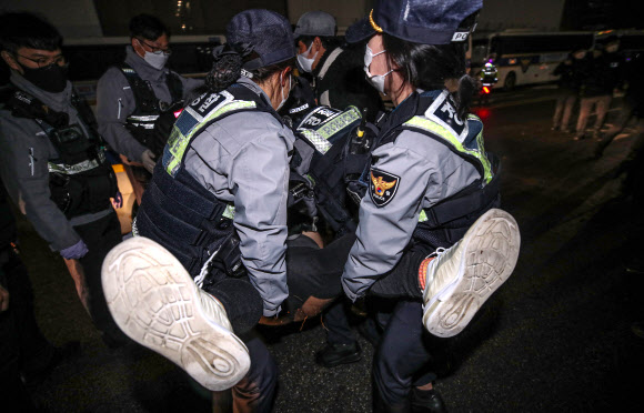 9일 오전 6시께 서울 종로구 옛 일본대사관 앞에서 ‘자유연대’를 비롯한 시민단체 회원들이 일본군 위안부 문제 관련 집회를 하기 위해 평화의 소녀상으로 진입을 시도하며 소녀상을 지키며 철야 시위를 벌이던 ‘반일행동’ 회원들과 마찰을 빚었다. 이에 평화의 소녀상 보호와 질서 유지를 위해 출동한 경찰이 소녀상 앞으로 진입을 시도하는 ‘자유연대’ 회원들의 진입을 저지했다.  사진은 평화의 소녀상 앞으로 진입을 시도하다 저지된 자유연대 회원을 경찰이 이동시키는 모습. 2021.11.9  연합뉴스