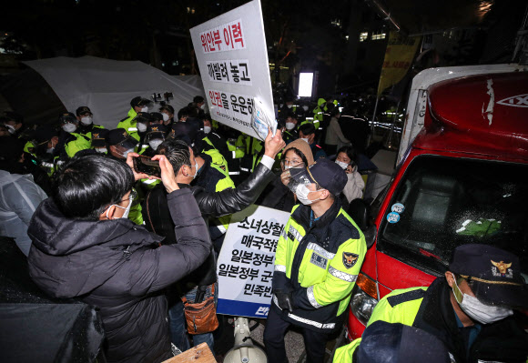 9일 오전 6시께 서울 종로구 옛 일본대사관 앞에서 ‘자유연대’를 비롯한 시민단체 회원들이 일본군 위안부 문제 관련 집회를 하기 위해 평화의 소녀상으로 진입을 시도하며 소녀상을 지키며 철야 시위를 벌이던 ‘반일행동’ 회원들과 마찰을 빚었다. 이에 평화의 소녀상 보호와 질서 유지를 위해 출동한 경찰이 소녀상 앞으로 진입을 시도하는 ‘자유연대’ 회원들의 진입을 저지하고 있다. 2021.11.9  연합뉴스