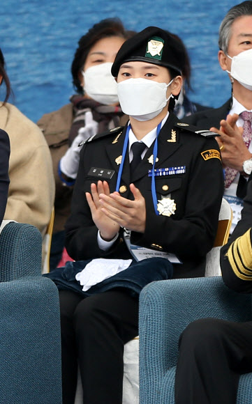 9일 오후 울산 현대중공업에서 열린 해군 신형 호위함 7번함인 ‘천안함’ 진수식에서 2010년 천안함 폭침 희생자인 고 김태석 원사의 자녀로 해군에 지원한 김해나 씨가 참석해 손뼉을 치고 있다. 2021.11.9  연합뉴스