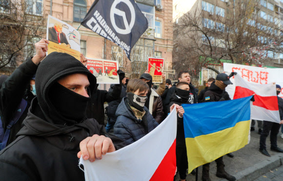 ‘민족 저항’ 운동의 우크라이나 활동가들이 10일(현지시간) 우크라이나 키예프의 벨라루스 대사관 앞에서 알렉산드르 루카셴코 벨라루스 대통령이 난민을 이용해 폴란드를 테러하려는 것에 대한 항의 시위를 벌이고 있다. 키예프 EPA 연합뉴스