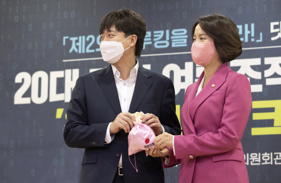 이준석 국민의힘 대표(왼쪽)와 이영 디지털정당위원장이 14일 국회 의원회관 제2소회의실에서 열린 ‘20대 대선 여론조작 방지를 위한 온라인 싸드, 크라켄 공개’행사에서 비단주머니를 들고 기념촬영을 하고  있다. 2021.11.14 김명국 선임기자 daunso@seoul.co.kr