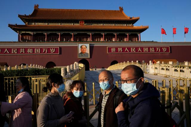 지난달 15일 중국 베이징에 마스크를 쓴 시민들이 지나고 있다. AP 연합뉴스
