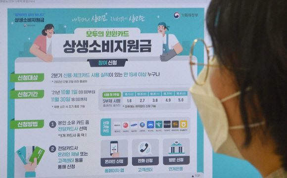 지난 9월 30일 서울의 한 사무실에서 한 시민이 신용카드 캐시백 지급 요건 등을 안내하는 팸플릿을 살펴보고 있다. 연합뉴스