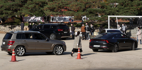 2022학년도 대학수학능력시험 예비소집일인 17일 서울 중구 이화여자외국어고등학교에서 수험생들이 드 수험표를 배부받고 있다. 2021. 11. 17. 사진공동취재단