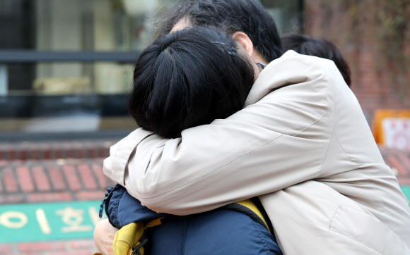 대학수학능력시험일인 18일 오전 고사장인 중구 이화여고에서 한 수험생이 부모와 인사하고 있다. 2021.11.18  연합뉴스