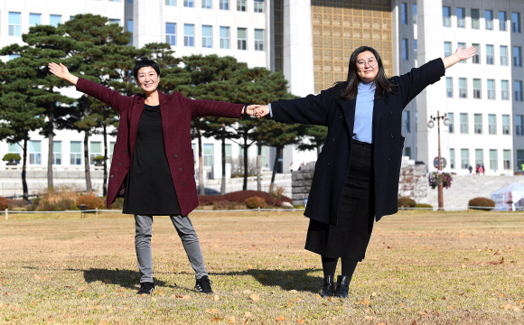 이안소영(왼쪽) 여성환경연대 상임대표와 안현진 활동가가 18일 서울 여의도 국회 앞에서 두 팔을 활짝 펼쳤다. 2017년 일회용 생리대의 유해성을 공론화하고 4년여를 끈 소송 끝에 승소한 뒤 되찾은 웃음이다. “에코페미니즘 중에서도 여성과 환경운동 모두에서 소외되던 이슈가 ‘생리대’였다고 생각했다”는 이들은 “그것이 누군가에게는 급박하고 중요한 사안일 수 있고, 우리는 그런 것들을 챙기고 있다”고 말했다. 오장환 기자 5zzang@seoul.co.kr